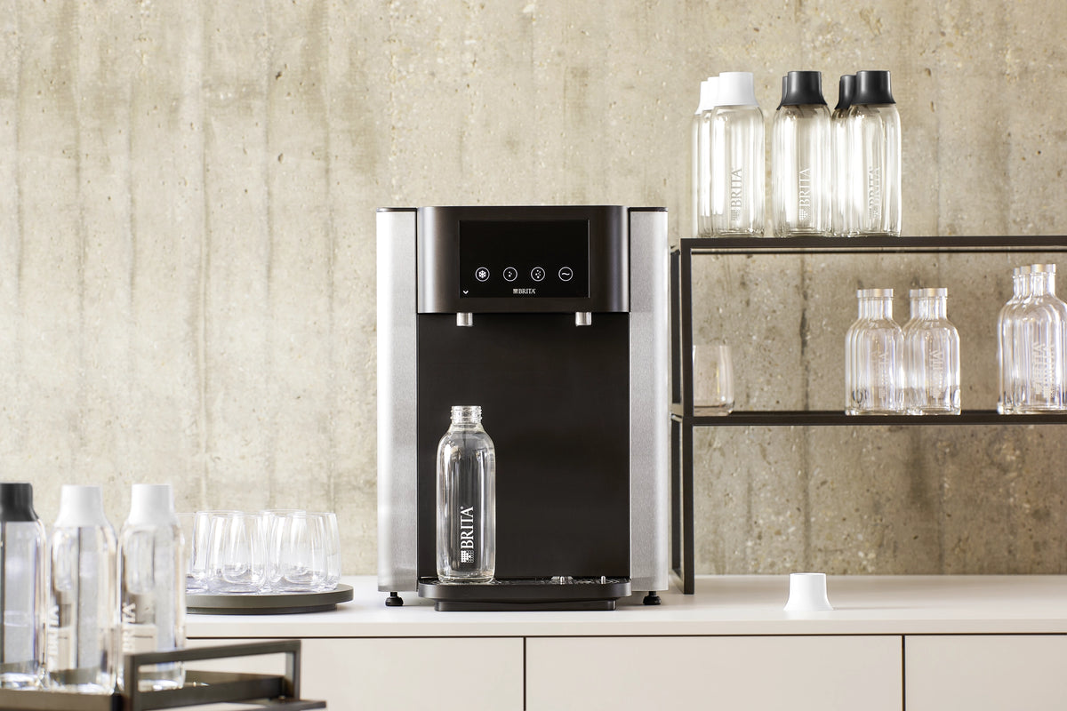 Fill Pro dispenser standing on a countertop with a glass bottles standing underneath the outlet