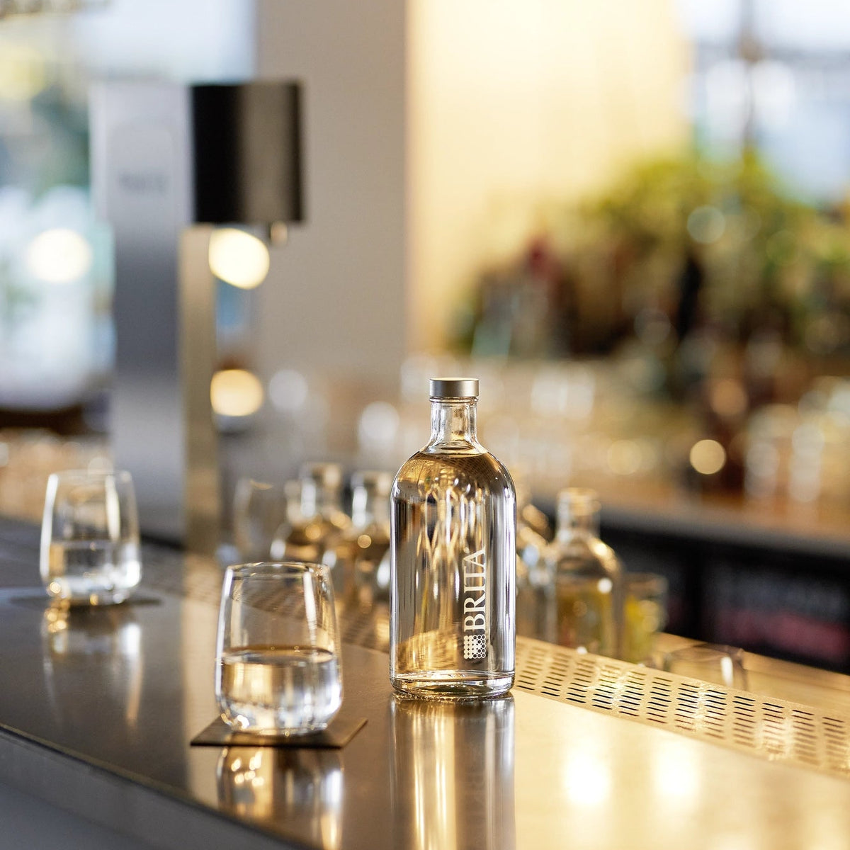 BRITA Lounge Bottle on a bar counter with glasses and a Fill T-Tap in the background.